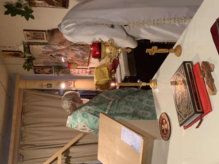 Two priests in green vestments serving at the altar